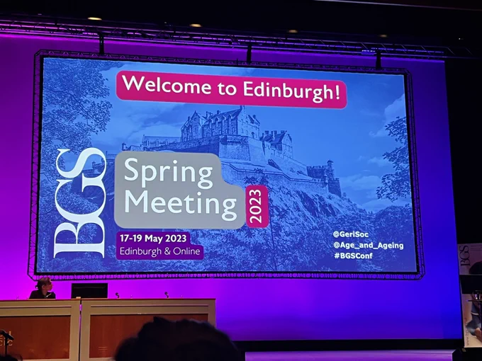 Shows a conference projection screen with a picture of Edinburgh castle. It reads: Welcome to Edinburgh! BGS spring meeting 2023. 17-19 May 2023z Edinburgh & online. @gerisoc @age_and_ageing #BGSConf