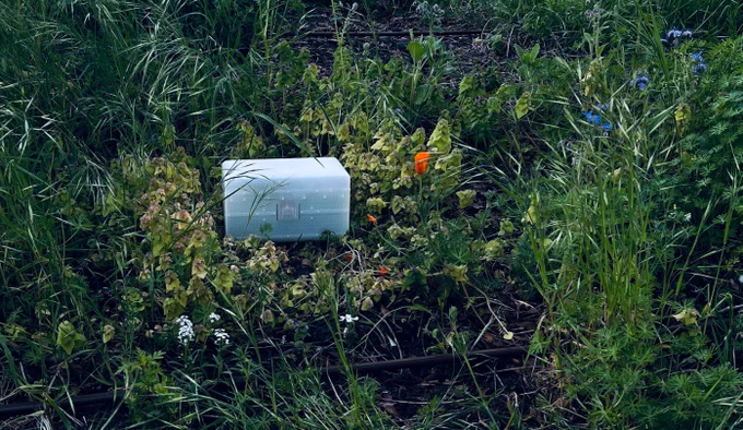 a white plastic box sitting in a grassy field