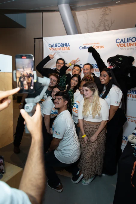 Photo of College Corps Fellows, Josh Fryday and a panther mascot posing for a picture in a photo booth