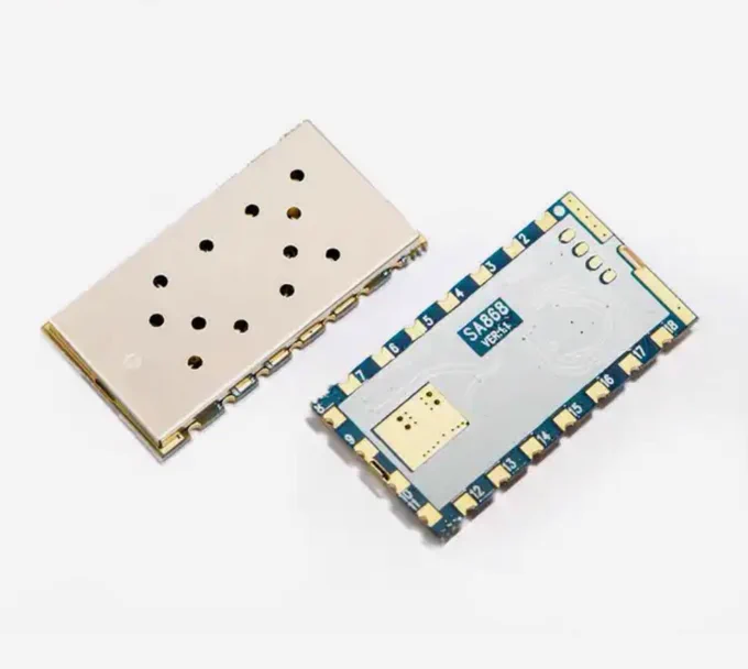 Picture of two SA868 modules, they have a metal RF cage on top and a blue pcb on the bottom with castellated pads.