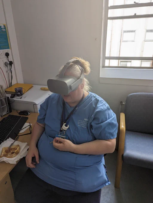 Nurse sat down in break room wearing VR headset experiencing the VR simulator Hypo