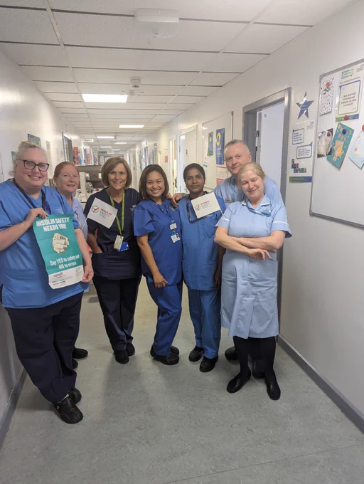 Nursing staff holding Posters and small paper flags with the insulin safety week logo on