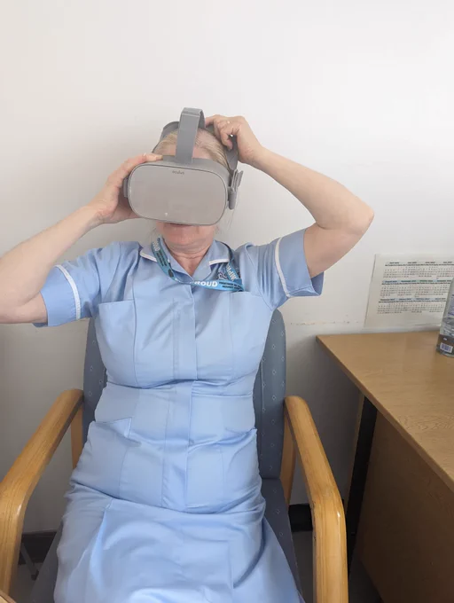 HCA sat down in chair holding on to VR headset while experiencing the Hypo simulator experience