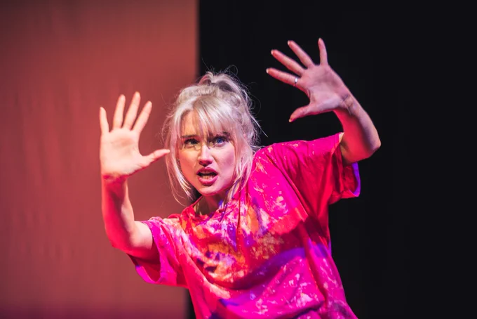 PRODUCTION SHOT: Alice looking at her hands both stretched out in front of her slightly confused