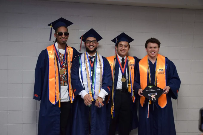 Graduates pose for a photo backstage.
