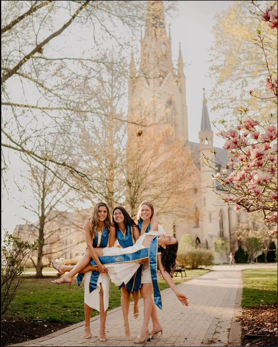 Four seniors pose for graduation pictures in front of the Basilica.
