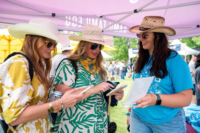 KAMU worker talking with two festival attendees.