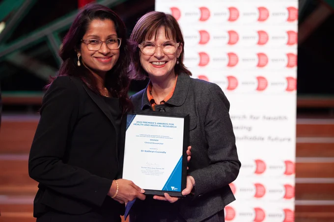 A photograph of Dr Rangi Kandane-Rathnayake picking up Dr Kathryn Connelly's award, the Clinical Researcher award, from The Hon Mary-Anne Thomas MP, Minister for Medical Research