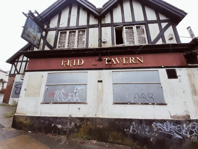 A picture of a boarded up closed pub.