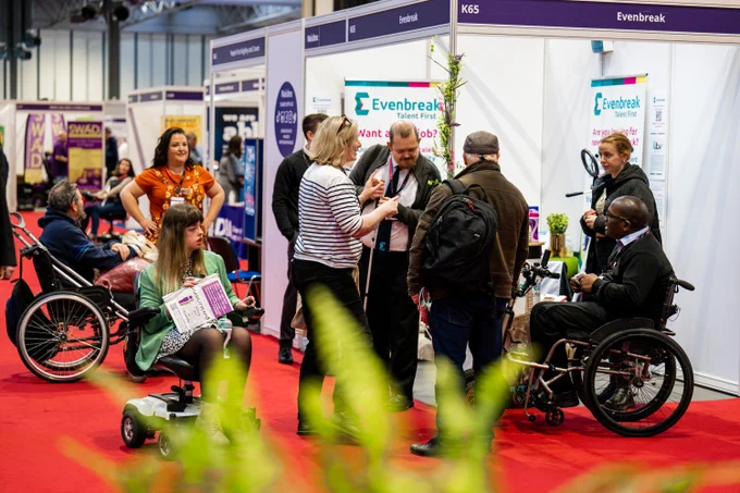 A group of visitors attending the Evenbreak stand at Naidex and speaking with their staff