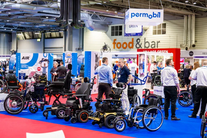 Permobil stand at Naidex with blue flooring 