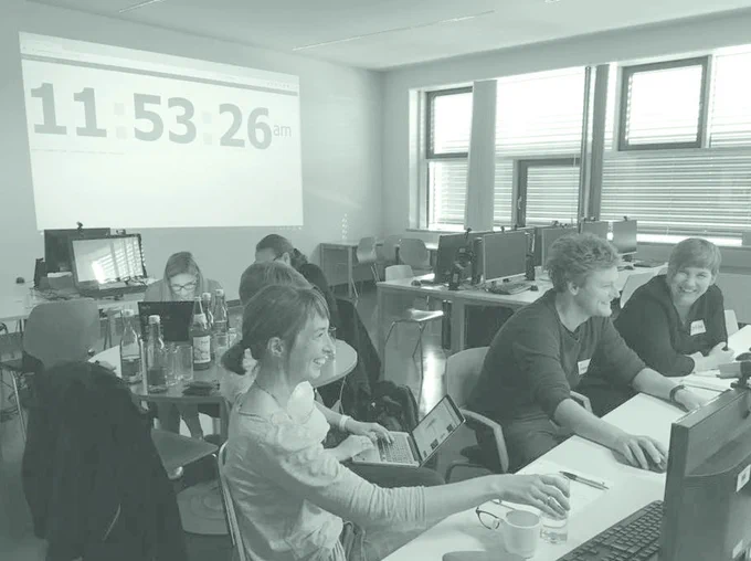Foto eines früheren Hackathons. Menschen am Computer.