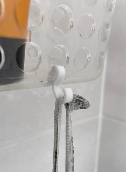 Ein kleiner Kunststoffhaken, an dem ein Seifenstück hängt.