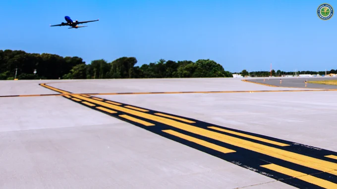 A commercial plane takes off from an airport runway with markings