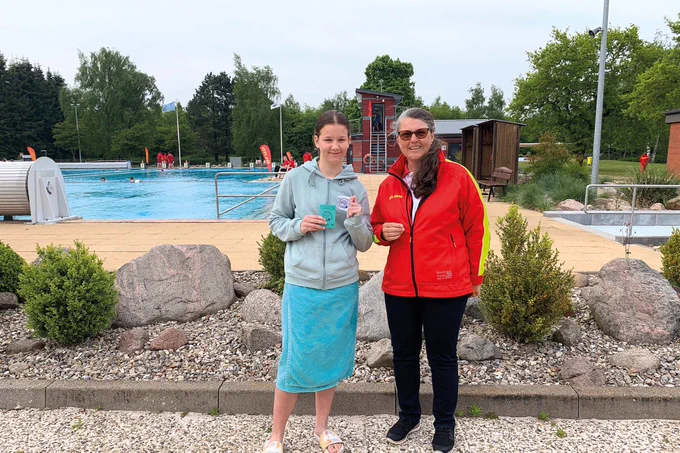 DLRG Präsidentin Ute Vogt gibt im Freibad in Kropp ein Schwimmabzeichen an eine Teilnehmerin aus.