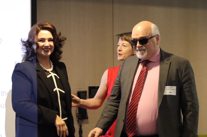 Commissioner Dalli standing beside EDF President Yannis Varskastanis.  EDF Director Catherine Naughton visible in the background.