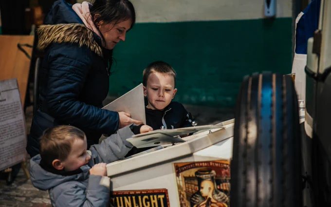 Two young boys and their mother look at a display in the National Emergency Services Museum.