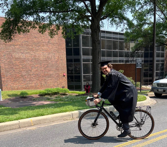 Me, on a bike, in academic regalia.