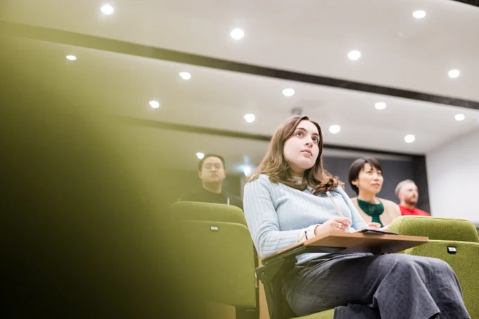 Upwards angle shot of 4 students sitting in a lecture theatre