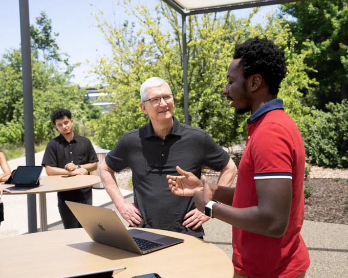 A Swift Student Challenge winner chats with Tim outside at Apple Park.