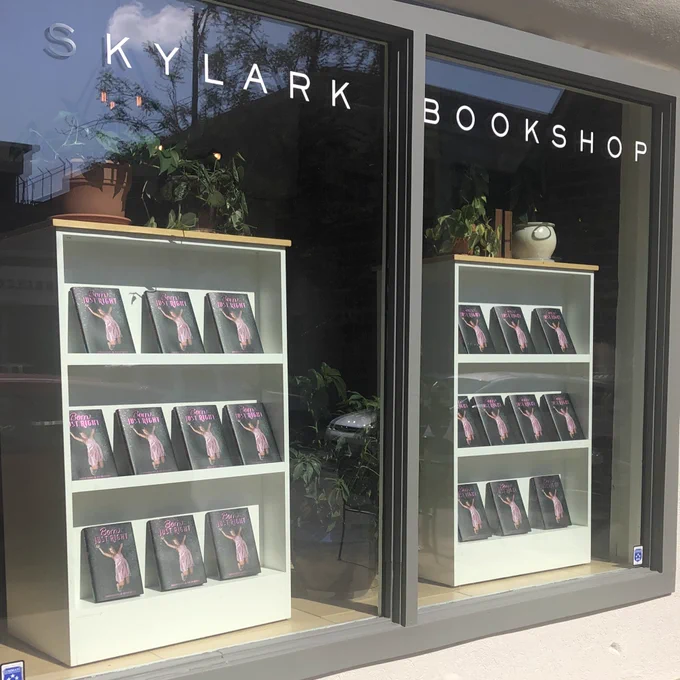 Windows of Skylark Bookshop with 2 bookshelves on display with nothing but copies of Born Just Right.