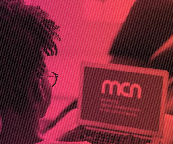 Stylised image of someone looking at a laptop with the MCN logo on the screen.