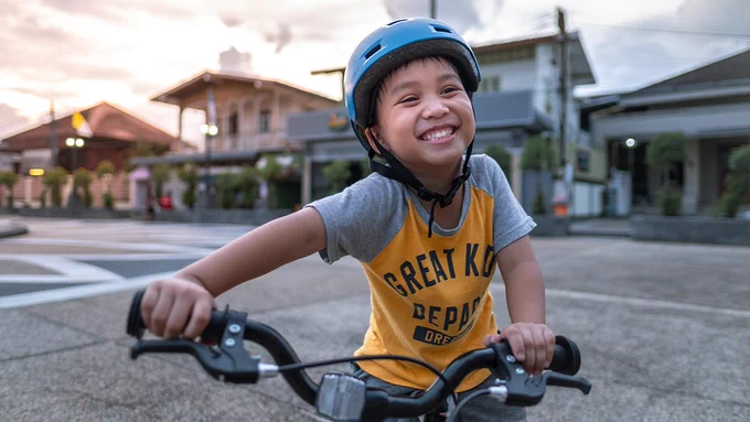 Photo of a child with a helmet on a bike 