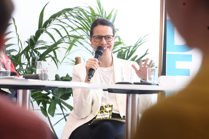 Ana Dujić, Abteilungsleiterin der Denkfabrik sitzt auf dem Podium und spricht in das Mikrofon.