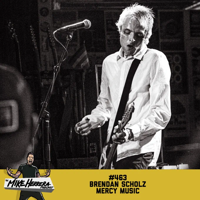 Singer guitar player Brendan Scholz with bleached hair playing guitar with band Mercy Music.