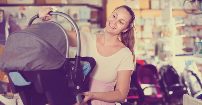 Woman holding an infant car seat.