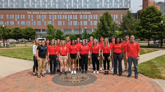 Group of MAT students wearing AT polos standing in front of the James Cancer hospital 