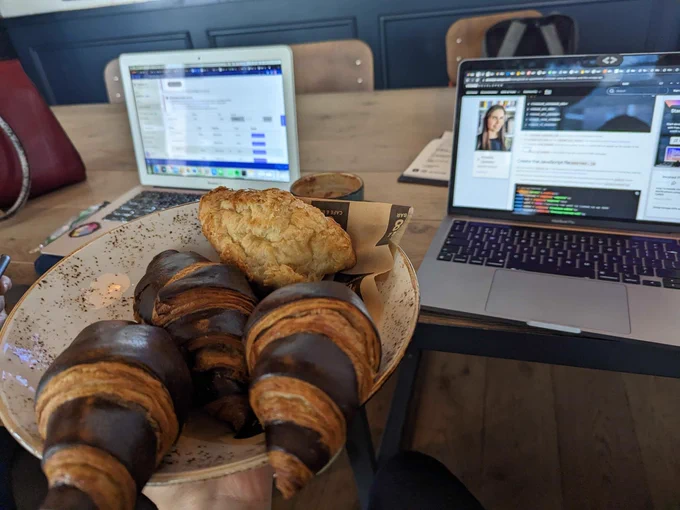 A bowl with croissants, and computers in the background.