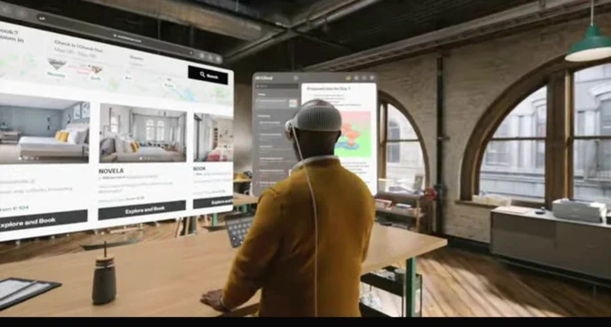 person using new Apple Vision Pro AR headset in office with multiple screens