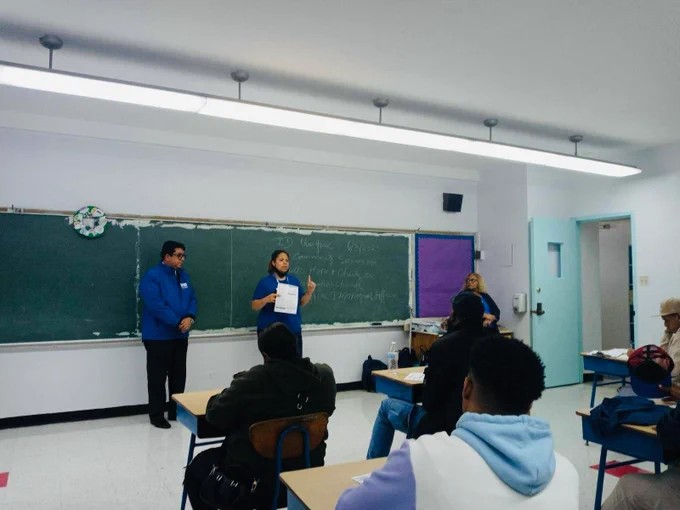 A woman is giving a presentation in a class.
