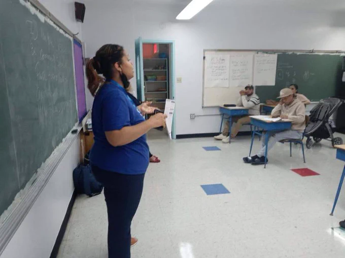 A woman is giving a presentation in a class.
