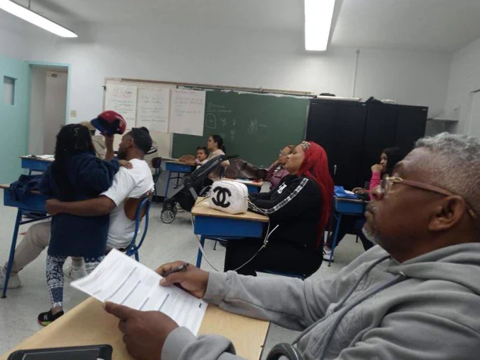 People listen to a presentation inside a classroom.