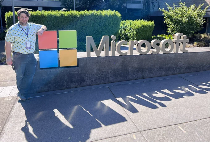 Sean standing with the Microsoft sign with a shadow cast on the ground