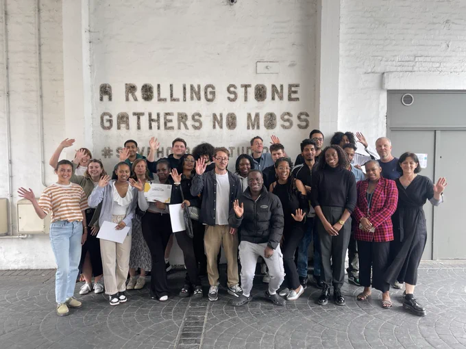 young people from city & islington college and Open staff smile for a photo outside of Holborn Studios