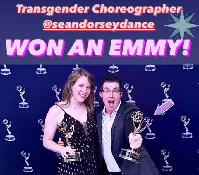 Image shows Director Lindsay Gauthier and Choreographer Sean Dorsey dance smiling widely and each holding an Emmy Award statue. They are standing in front of a step-and-repeat banner with repeating images of an Emmy statue on it. Text on image reads "Transgender Choreographer @SeanDorseyDance won an Emmy!"