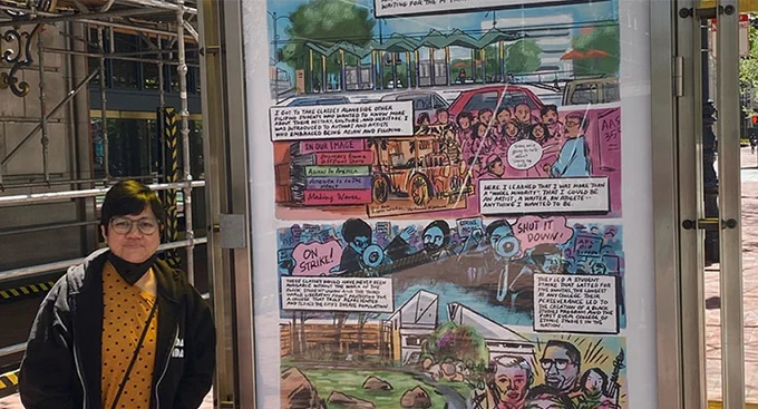 Rina stands next her comic art that is on display at a San Francisco bus stop hutch. 