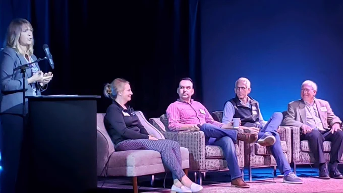 panel of guests sitting on a stage 