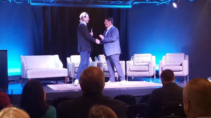 Portsmouth Of Mayor and NE Regional Administrator of SBA shake hands on stage, 