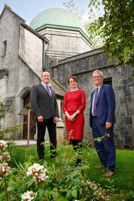 Dr Patrick O’Leary, Dr Máirín MacCarron, and Prof John O'Halloran outdoors on the grounds of University College Cork, with a building in the background.