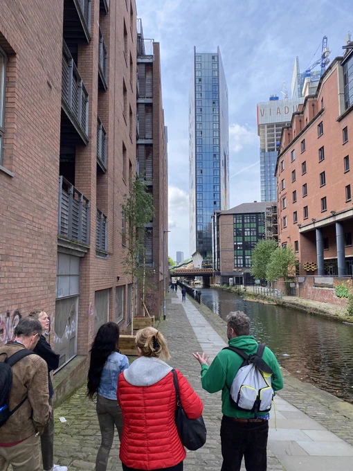 A group on a guided walking tour alongside the former Hacienda club by the Rochdale Canal, Manchester.