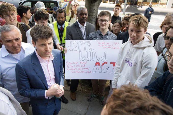 Sam Altman talks to students protesting outside the IOE building about the risks that AI might pose. The students held up signs calling for a pause in the development of advanced AI systems. 