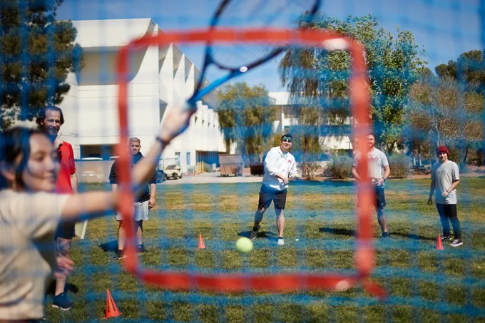 A student throws a ball at a net 