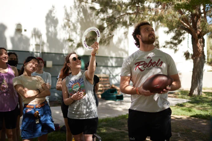 A group of students look at a frisbee and football