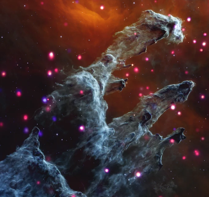 An image of the Eagle Nebula, also called M16, and often referred to as the "Pillars of Creation". Here, tall columns of gray gas and dust emerge from the bottom edge of the image, stretching toward our upper right. Backed by dark orange mist, the cloudy gray columns are surrounded by dozens of soft, glowing, pink and purple dots; massive stars emitting enormous amounts of X-rays. The shapes, hints of movement, and colors in this composite rendering create a dream-like image. The misty orange background suggests a dusky sky, and the glowing pink and purple stars resemble fireflies. Churning with turbulent gas and dust, the columns lean to our right with small offshoots pointing in the same direction. These details evoke an image of yearning cloud creatures at dusk, pointing at something just out of frame.