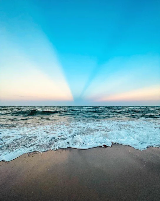 A sunrise illuminates the sky above the surf on Miami Beach.