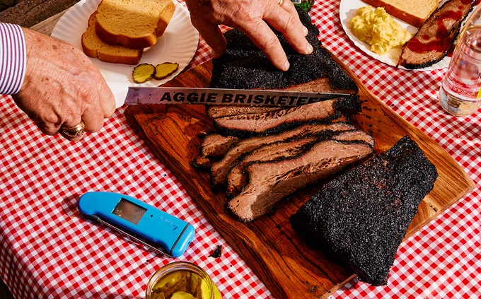 Ray Riley 79, 81 slicing a perfectly cooked brisket with his Aggie Brisketeer knife